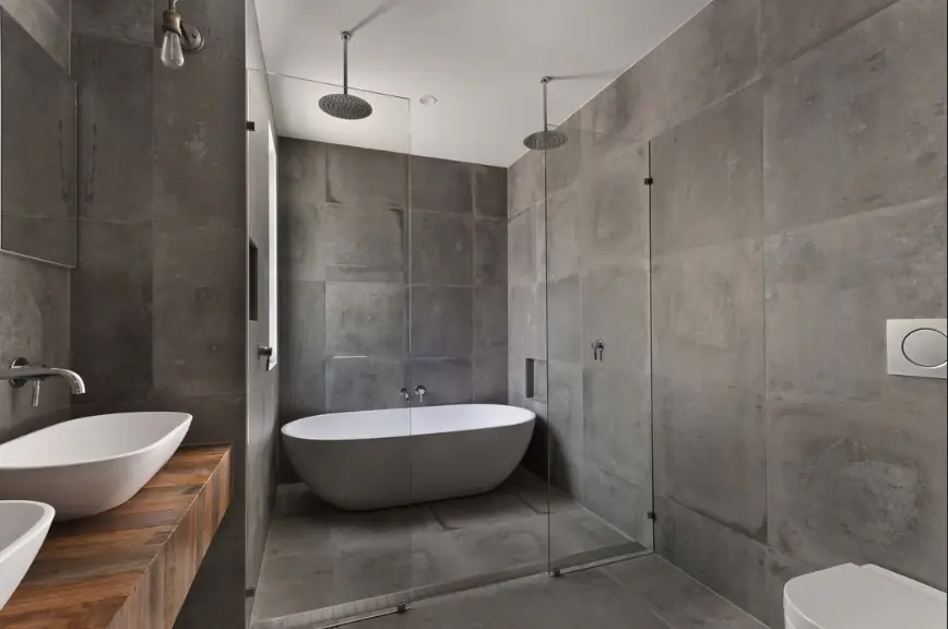 Frameless panel beside a freestanding tub